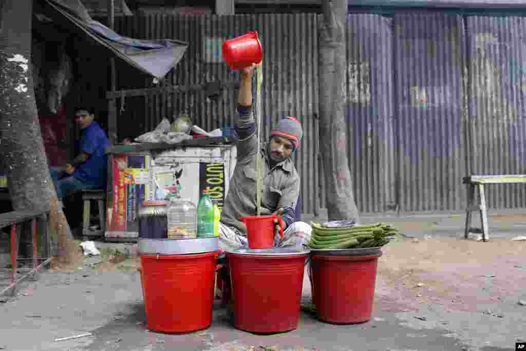 A street vendor prepares herbal juice for sale in Dhaka, Bangladesh.