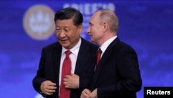 На фото: Червень 2019, Володимир Путін та Сі Цзіньпін спілкуються на Петербурзькому міжнародному економічному форумі