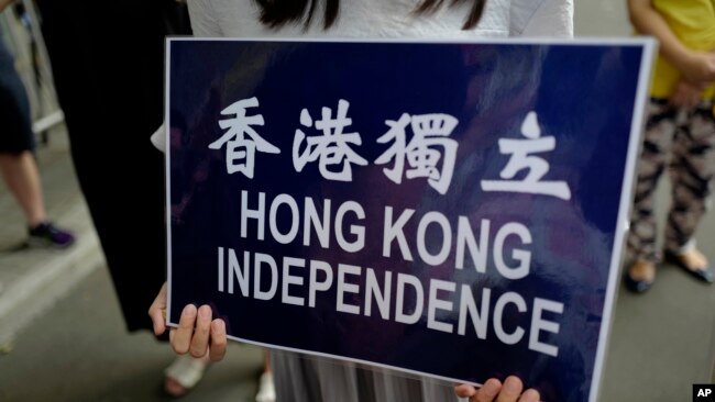 在香港警察总部前抗议的民众手持香港独立的标语。（2018年9月25日）