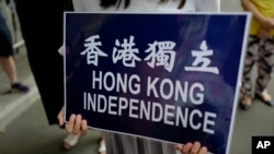 A protester raises a placard during a protest outside the police headquarter in Hong Kong, Sept. 25, 2018. 