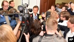 Julian Assange's lawyer Tomas Olsson, center, talks to media prior to a public court hearing in Stockholm, Sweden, July 16, 2014. 