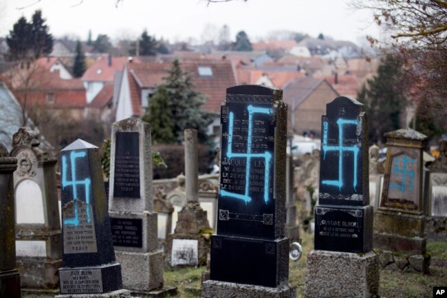 FILE - Vandalized tombs with tagged swastikas are pictured in the Jewish cemetery of Quatzenheim, eastern France, Feb.19, 2019.