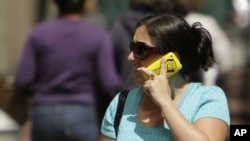 FILE - A woman talks on her cellphone while walking along First Street in San Francisco. NTP scientists and the U.S. Food and Drug Administration say current safety limits on cellphone radiation are protective.