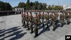 Members of pro-defense forces attend a parade in front of the Tomb of the Unknown Soldier during the first nationwide rally, in Warsaw, Poland, Thursday, Sept. 17, 2015.