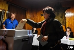 A woman casts her ballot during the first round of the presidential election at a polling station in Prague, Jan. 12, 2018.