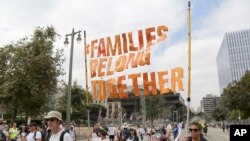 ARCHIVO - Manifestantes con carteles participan en la marcha "Las Familias Deben Estar Juntas: Libertad para los Inmigrantes", 30 de junio de 2018, en Los Ángeles. En las principales ciudades y pueblos pequeños, los manifestantes se reunieron en todo Estados Unidos, movidos por las historias de los niños separados de sus padres en la frontera.