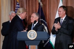 President Donald Trump shakes hands with EPA Administrator Scott Pruitt, flanked by Vice President Mike Pence and Interior Secretary Ryan Zinke, March 28, 2017, at EPA headquarters in Washington.