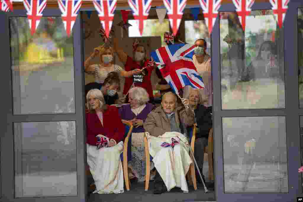 Residents wave to Britain&#39;s Prince William and Kate, Duchess of Cambridge, as they visit Cleeve Court Care Home in Bath, England, Dec. 8, 2020, on the final day of a three-day tour across the country.