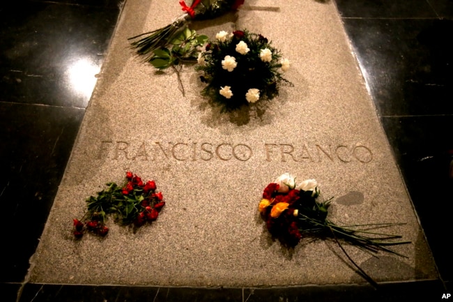 FILE - Flowers are placed on the tomb of former Spanish dictator Francisco Franco inside the basilica at the Valley of the Fallen monument near El Escorial, outside Madrid, Aug. 24, 2018.
