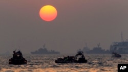 The orange sun begins to set as searchers and divers look for bodies of passengers believed to have been trapped in the sunken ferry Sewol in the water off the southern coast near Jindo, south of Seoul, South Korea, April 22, 2014.