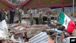 Soldiers remove debris from a partly collapsed municipal building felled by a massive earthquake in Juchitan, Oaxaca state, Mexico, Friday, Sept. 8, 2017. One of the most powerful earthquakes ever to strike Mexico has hit off its southern Pacific coast, k