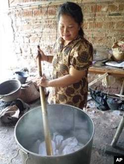 One of the members of the batik cooperative stirs fabric in boiling water to prepare it for dyeing, Kebon Central Java, 4 April 2010