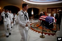 U.S. Naval sea cadets walk past the casket to pay their respects to Sen. John McCain, R-Ariz. at the Arizona Capitol in Phoenix, Aug. 29, 2018.