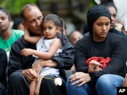 Mahmoud Hassanen Aboras father of Nabra Hassanen, who was killed over the weekend in a road rage incident, left, sits with family as he listens to speakers during a vigil in honor of Nabar Wednesday, June 21, 2017, in Reston, Virginia.