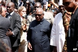 FILE - Malian President Ibrahim Boubacar Keita returns to his car after addressing reporters outside the Radisson Blu hotel in Bamako, Mali, Nov. 21, 2015.