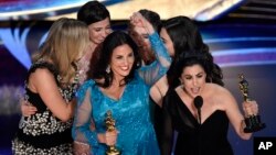 Melissa Berton, center left, and Rayka Zehtabchi accept the award for best documentary short subject for "Period. End of Sentence." at the Oscars, Feb. 24, 2019, at the Dolby Theatre in Los Angeles.