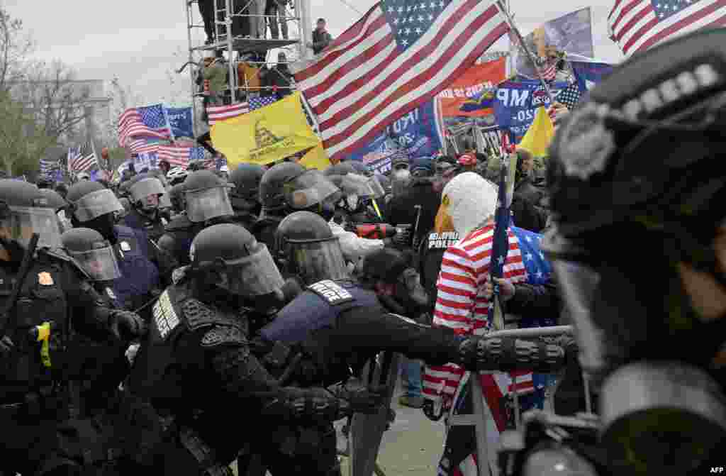 Les partisans de Trump se heurtent à la police et aux forces de sécurité alors qu&#39;ils tentent de prendre d&#39;assaut le Capitole américain entouré de gaz lacrymogènes à Washington DC, le 6 janvier 2021. (Photo par Joseph Prezioso / AFP)