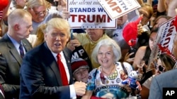 Republican presidential candidate Donald Trump, left, shouts to Secret Service agents that supporter Diana Brest, right, had been waiting in line since 2 a.m. to see the candidate speak at a rally, June 18, 2016, in Phoenix.