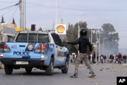 FILE - Protesters face police in Ennour, near Kasserine, Tunisia, Jan. 20, 2016. Tunisia declared a curfew in the western city at that time after clashes occurred between police and more than 1,000 young protesters demonstrating for jobs.