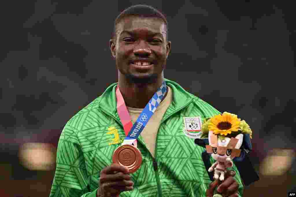 Bronze medallist Burkina Faso&#39;s Hugues Fabrice Zango poses with his medal on the podium after the men&#39;s triple jump event during the Tokyo 2020 Olympic Games at the Olympic Stadium in Tokyo on August 5, 2021. (Photo by Ina FASSBENDER / AFP)