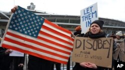 Demonstran di luar bandara internasional John F. Kennedy di New York, Sabtu, 28 Januari 2017.