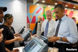 FILE - U.S. President Barack Obama, right, opens his wallet to buy lunch for himself and Vice President Joe Biden at a sandwich shop near the White House in Washington, D.C., Oct. 4, 2013.