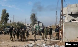 FILE - Iraqi rapid response forces gather during a fight with Islamic State militants in Intisar district of eastern Mosul, Iraq, Dec. 22, 2016.