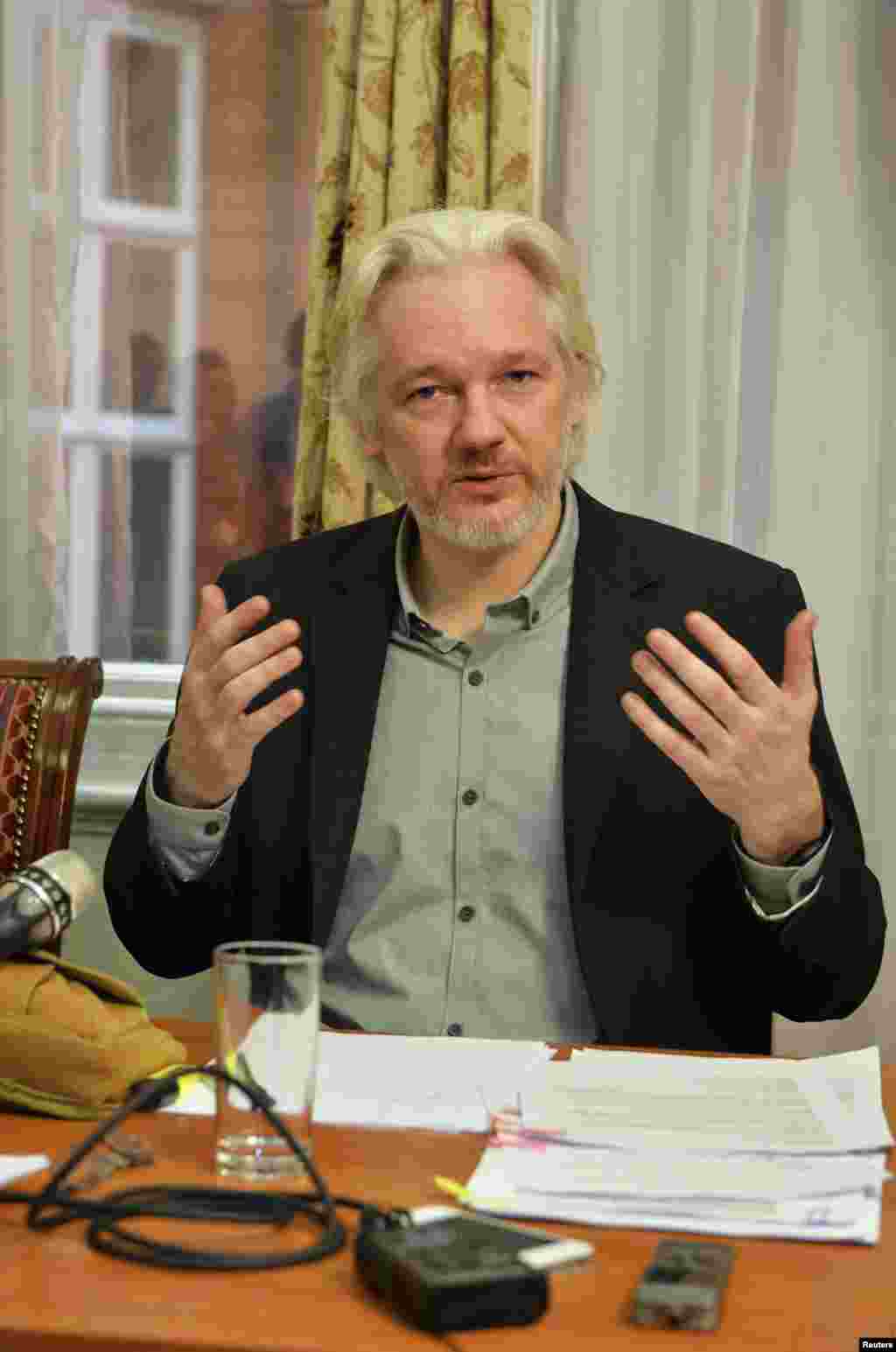 WikiLeaks founder Julian Assange gestures during a news conference at the Ecuadorian embassy, in central London, Aug. 18, 2014.