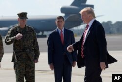 President Donald Trump passes Joint Chiefs Chairman Gen. Joseph Dunford, left, and National Security Adviser Michael Flynn as he arrives via Air Force One at MacDill Air Force Base in Tampa, Fla., Feb. 6, 2017.