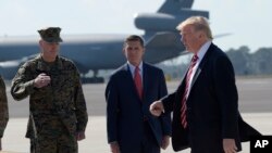 美国总统川普抵达佛罗里达的麦克迪尔空军基地，从参谋长联席会议主席邓福德上将和国家安全顾问弗林身边走过。（2017年2月6日）