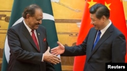巴基斯坦总统侯赛因（左）和中国国家主席习近平在北京人民大会堂的一次签字仪式上握手（资料照片）