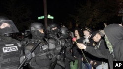 A protester offers police a rose after the deadline passed when the city wanted them to vacate the Occupy Portland Camp in Portland, Oregon, November 13, 2011.
