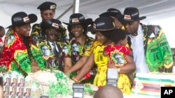 Le président zimbabwéen Robert Mugabe, centre gauche, son épouse Grace, au centre, et des membres de leur famille coupent le gâteau d'anniversaire à Matopos, dans la banlieue de Bulawayo, 25 février 2017. 