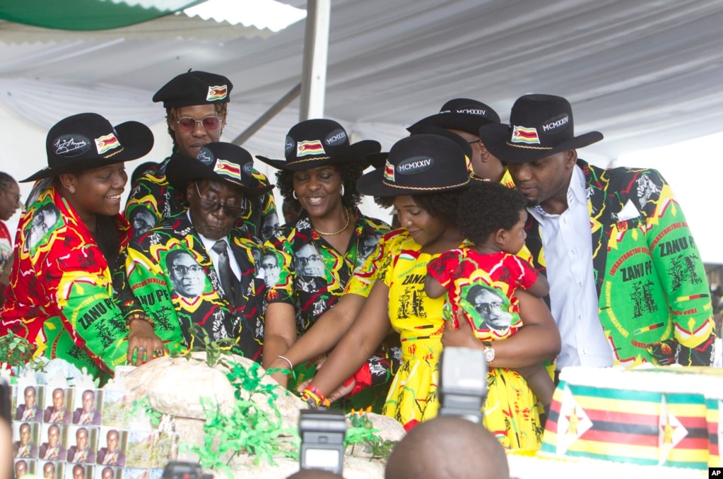 Zimbabwean President Robert Mugabe, center left, and his wife Grace, center are joined by his family as they cut the cake during his 93rd Birthday celebrations in Matopos on the outskirts of Bulawayo,&nbsp; Feb. 25, 2017.