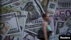 A woman walks past a currency exchange office in Sao Paulo, Brazil, Jan. 7, 2016.