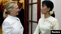 US Secretary of State Hillary Clinton and Burma pro-democracy leader Aung San Suu Kyi shake hands before dinner at the US Chief of Mission Residence in Rangoon, Burma, December 1, 2011.