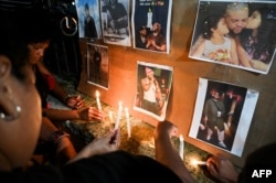 Los cubanos encienden velas junto a fotografías del fallecido cantante de reggaetón José Manuel Carbajal, "El Taiger", mientras le rinden homenaje en La Habana el 10 de octubre de 2024.