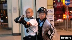 2019年7月30日一名警察举枪瞄准了在香港葵涌警署大楼前声援被拘捕的反送中抗议者的示威人群。