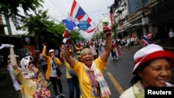 Para demonstran anti-pemerintah berbaris di jalanan pusat kota Bangkok untuk merayakan keputusan Mahkamah Konstitusi yang meminta PM Yingluck Shinawatra mundur (7/5). 