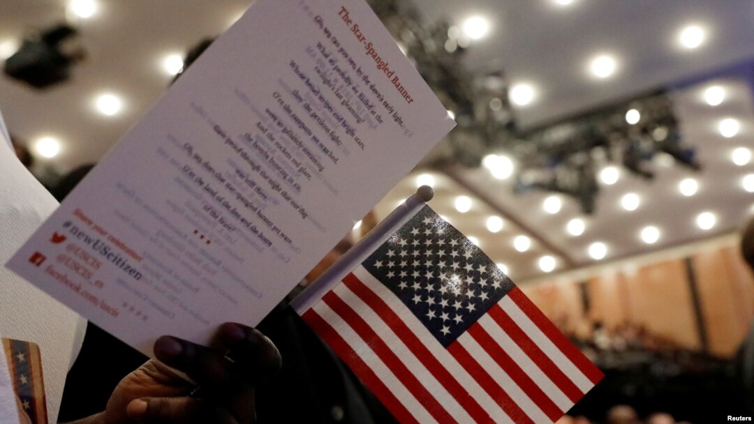 Nuevos ciudadanos de pie durante una ceremonia de naturalización del Servicio de Ciudadanía e Inmigración de los Estados Unidos (USCIS) en el Museo y Biblioteca de la Sociedad Histórica de Nueva York en Manhattan.