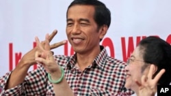 Calon presiden Joko Widodo dan mantan presiden sekaligus ketua Partai Demokrasi Indonesia Perjuangan Megawati Sukarnoputri. (AP/Dita Alangkara)