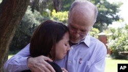 Arnold Pistorius, right, uncle of Olympic athlete Oscar Pistorius, comforts his niece after making a statement to selected press in Pretoria, South Africa, Feb. 16, 2013.