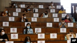 Students sit at a distance as a precaution against COVID-19 as they take an aptitude test for the University of Medicine in Rome on Sept. 3, 2020.