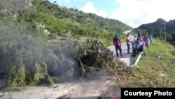 Wout prensipal Hench la moun nan zòn nan bloke paske konpayi kap fè wout la refize ba yo travay. Foto: Jounalis afilliye VOA, Raphael Givens. 25 septanm 2018 la. 