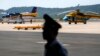 An officer stands guard near Vietnam aircraft before a mission to find the Malaysia Airlines flight MH370 that disappeared from radar screens Saturday, at Phu Quoc Airport on Phu Quoc Island, March 10, 2014.