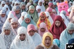 FILE —Muslims take part in Eid al-Fitr prayers, marking the end of the holy month of Ramadan, on a street in Jakarta on April 10, 2024.