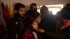 In this Feb. 12, 2020, photo, Malak Saad Dakhel, 11, is anointed by a holy man inside a Yazidi shrine as she is welcomed home by her relatives after her escape from Syria, in Sharia, Iraq.
