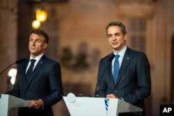 FILE - Greece Prime Minister Kyriakos Mitsotakis speaks flanked by French president Emmanuel Macron during a news conference, in Mdina, Malta, Friday, Sept. 29, 2023.