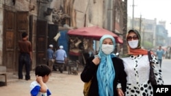 FILE - Uighur Muslim women wear headscarves while walking in China's Xinjiang Uighur Autonomous Region, June 14, 2008. China's crackdown on Islamic culture has spread to Hainan province, home to a small population of Utsuls, a Muslim ethnic group.