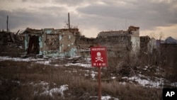 FILE - A sign that reads "Mines" is placed on the side of the road in the village of Kamyanka, Ukraine, on Feb. 19, 2023. In this war-scarred city in Ukraine's northeast, residents scrutinize every step for land mines.(Vadim Ghirda/AP Photo)